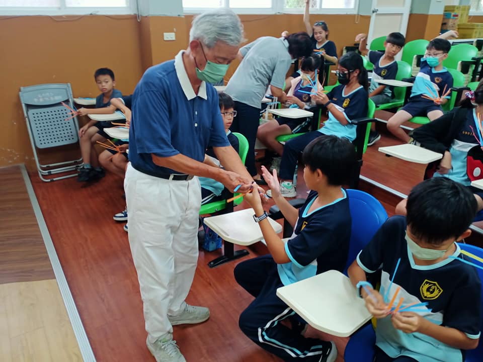 慈濟師兄指導孩子進行編織